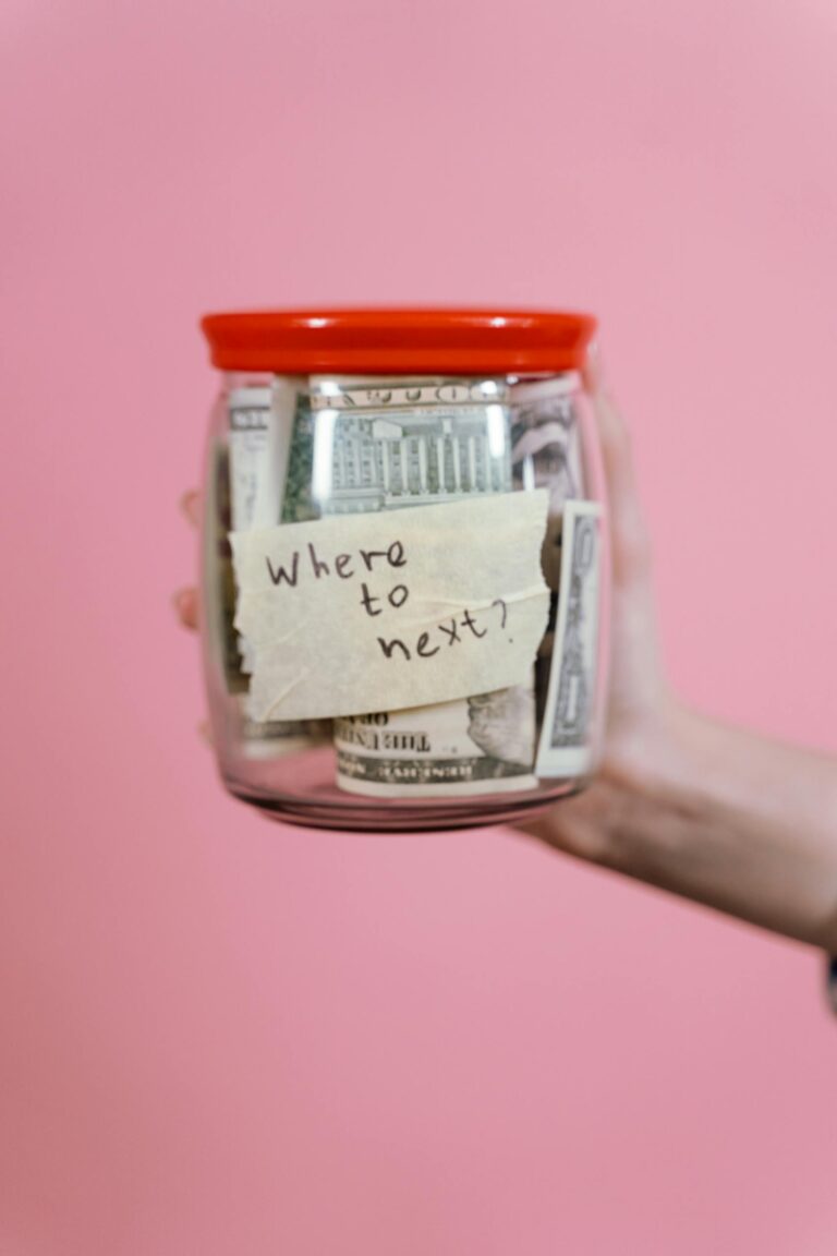 How to budget for moving abroad - jar filled with cash and a travel note symbolizing savings for expats
