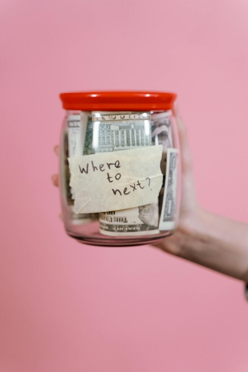 How to budget for moving abroad - jar filled with cash and a travel note symbolizing savings for expats