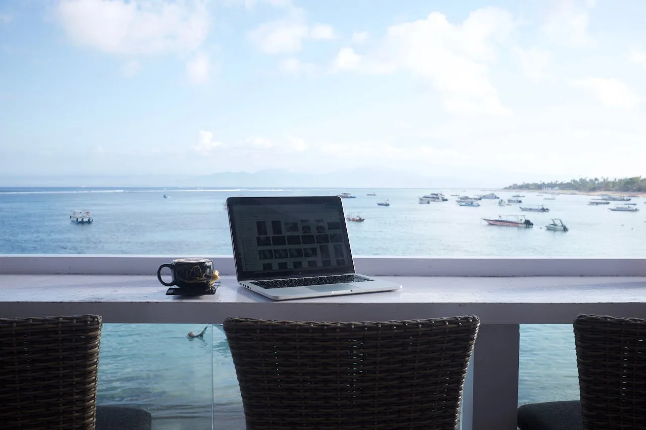 Digital nomad working on laptop with Bali sea view for bali digital nomad visa