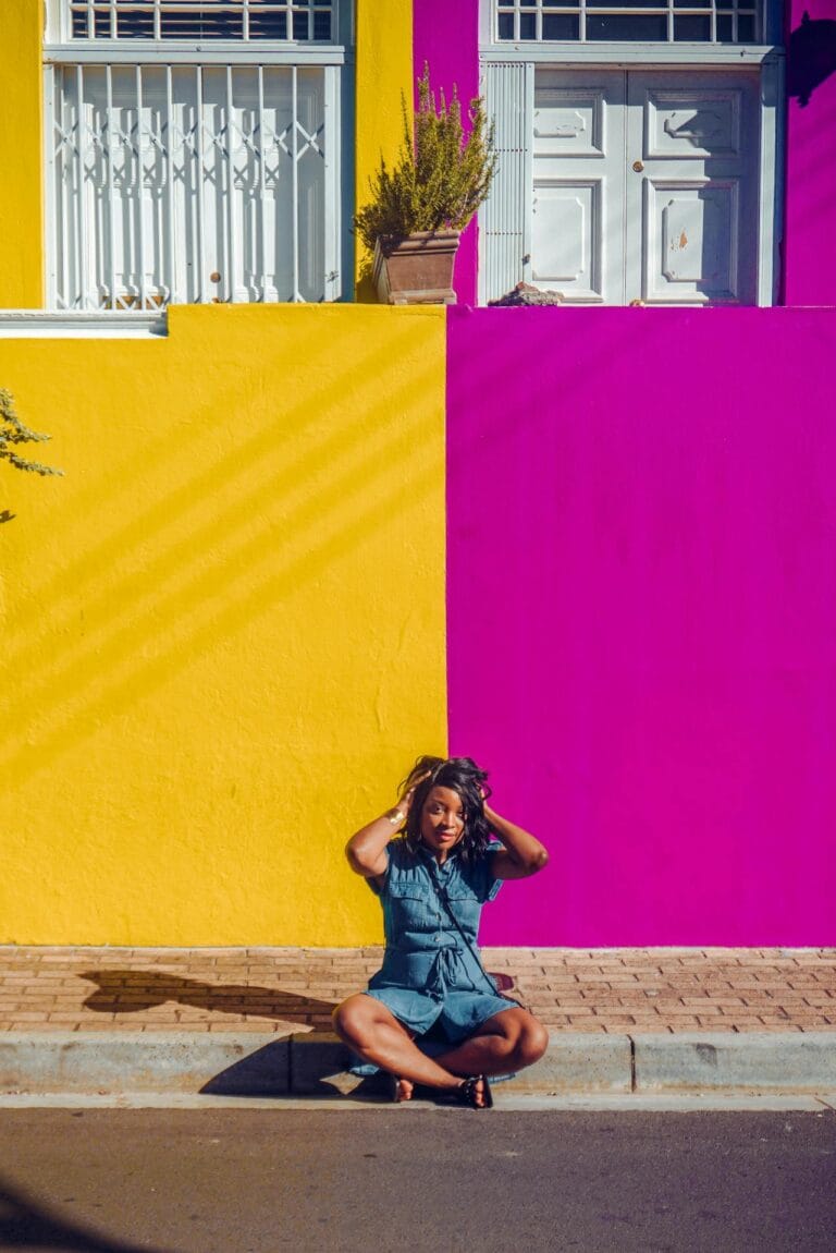 Black woman in front of colorful buildings in Cape Town South Africa