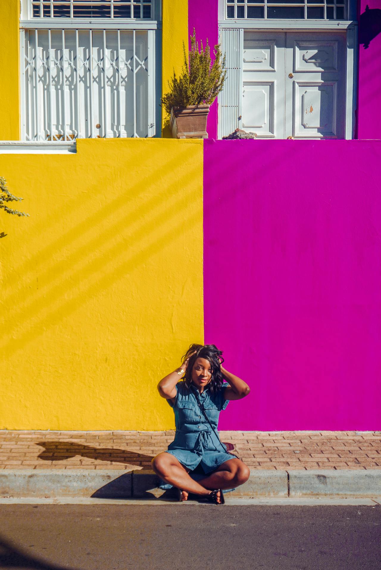 Black woman in front of colorful buildings in Cape Town South Africa
