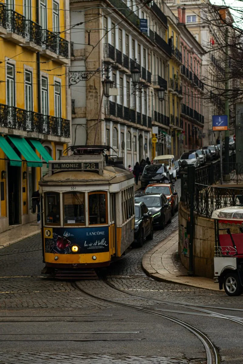 cheapest countries to live in for Americans - classic yellow tram on cobblestone streets of Lisbon Portugal
