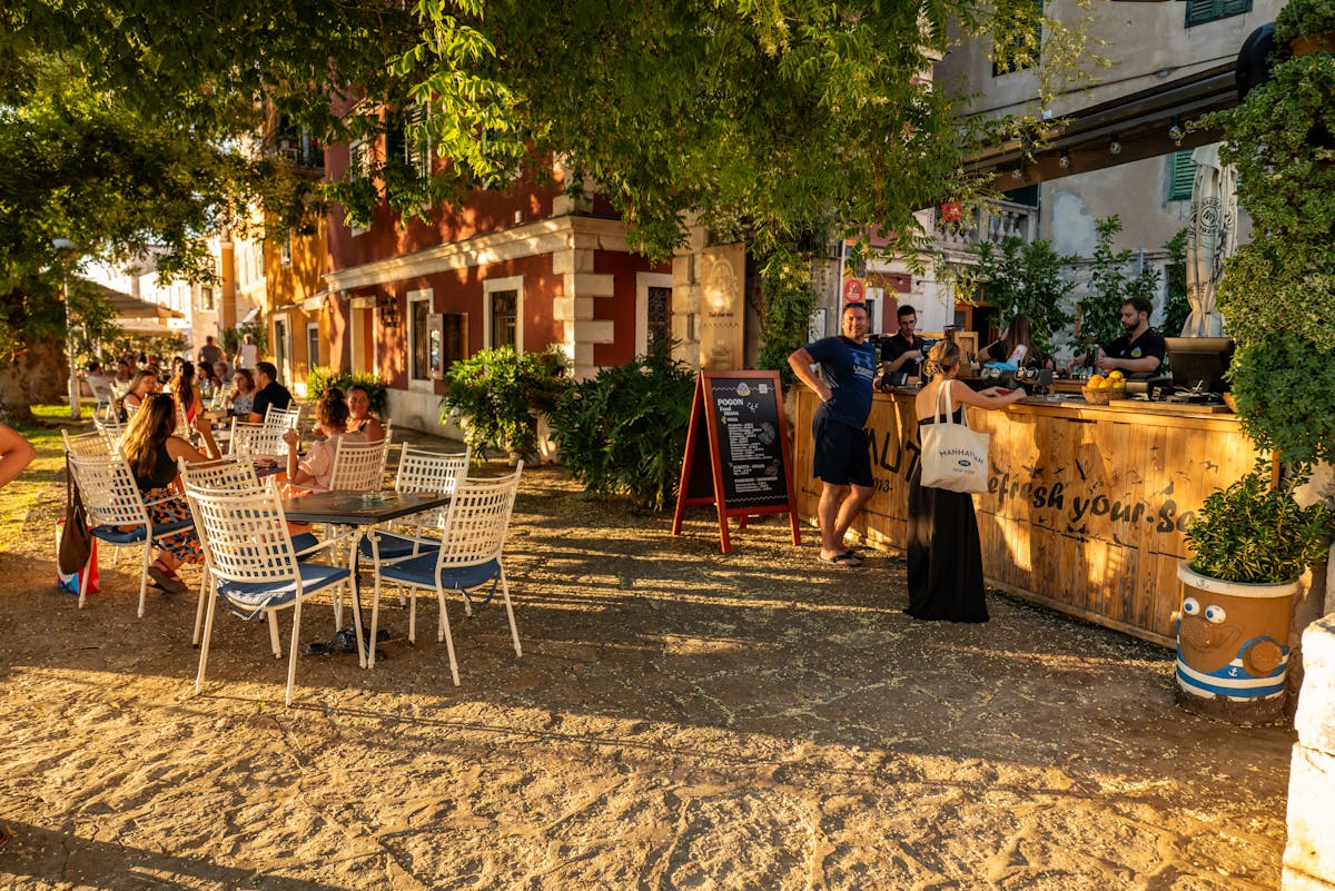 Outdoor cafe in Croatia with people dining on sunny summer evening - cost of living in Croatia for digital nomads