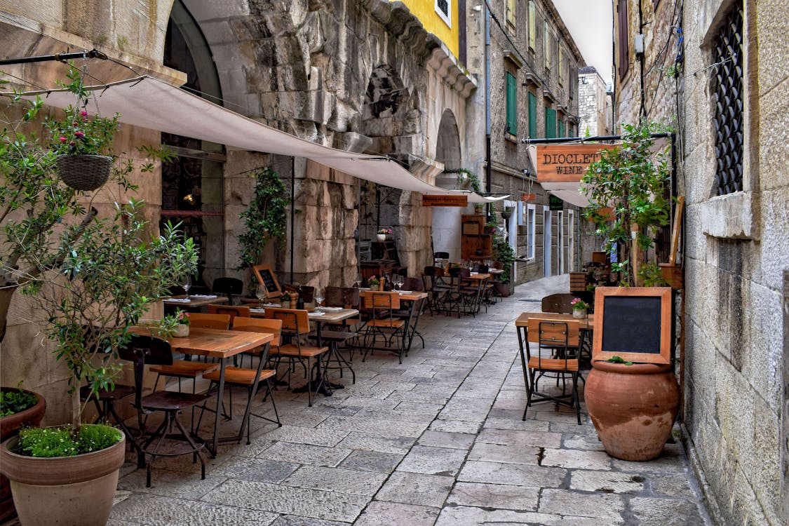 Outdoor restaurant tables in a stone alleyway in Croatia old town