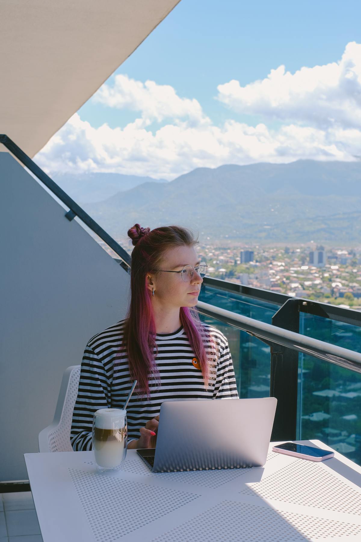 Digital nomad woman working on laptop on rooftop with city view - remote work in Croatia