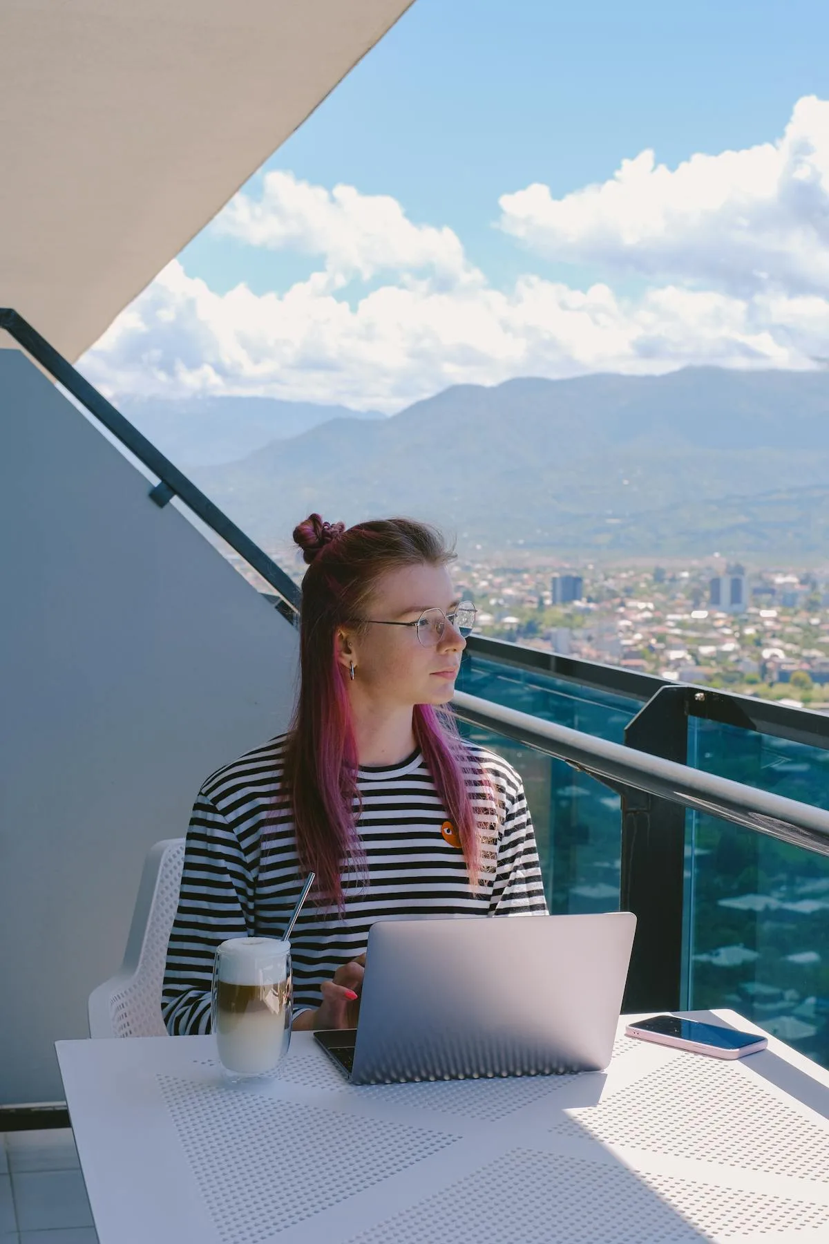 Digital nomad woman working on laptop on rooftop with city view - remote work in Croatia