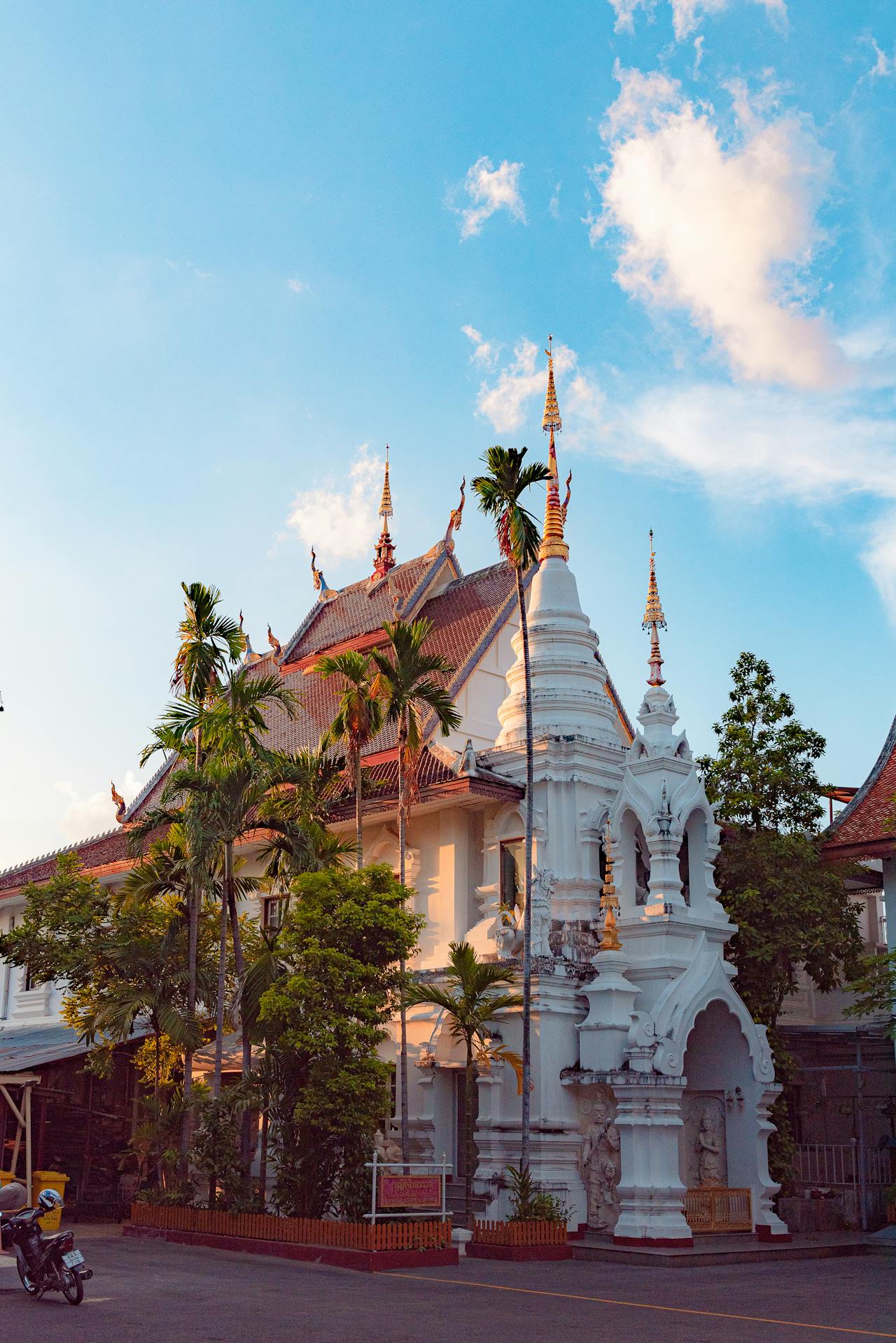 cost of living in chiang mai for americans - traditional Thai temple with golden spires and palm trees in Chiang Mai