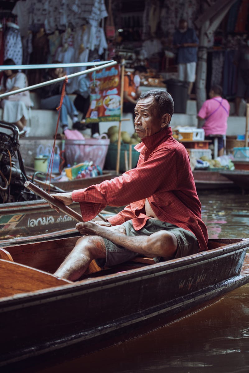 Living in Thailand for a month - man rowing boat at Bangkok floating market