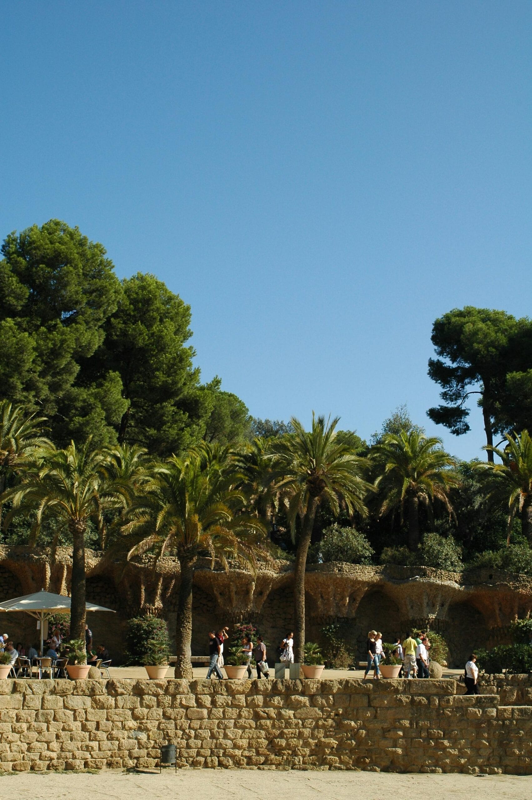 An American couple smiling and looking at a map while standing on a sunny street in a Spanish city with colorful buildings in the background.