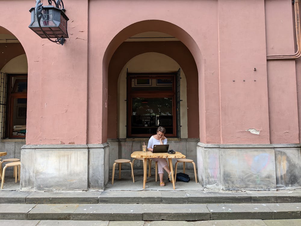 international health insurance for Americans - person working on laptop at outdoor cafe abroad