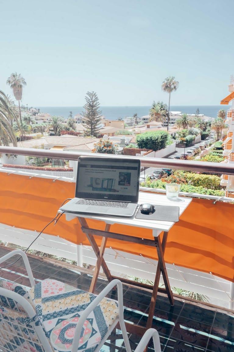 Spain digital nomad visa taxes - laptop on balcony terrace overlooking ocean in Tenerife Spain