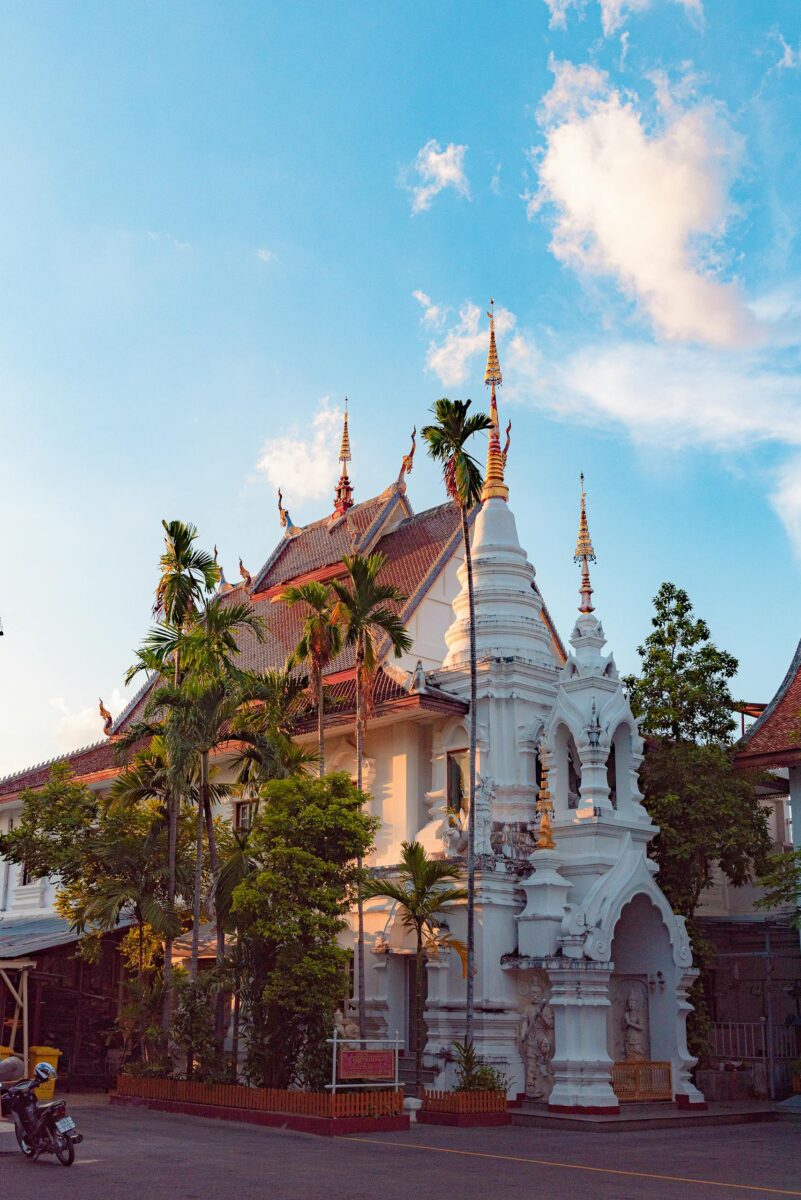 Moving to Thailand as an American: The Complete 2026 Guide 1 Stunning view of Wat Chiang Man temple in Chiang Mai, Thailand, during sunset with palm trees and clear skies.