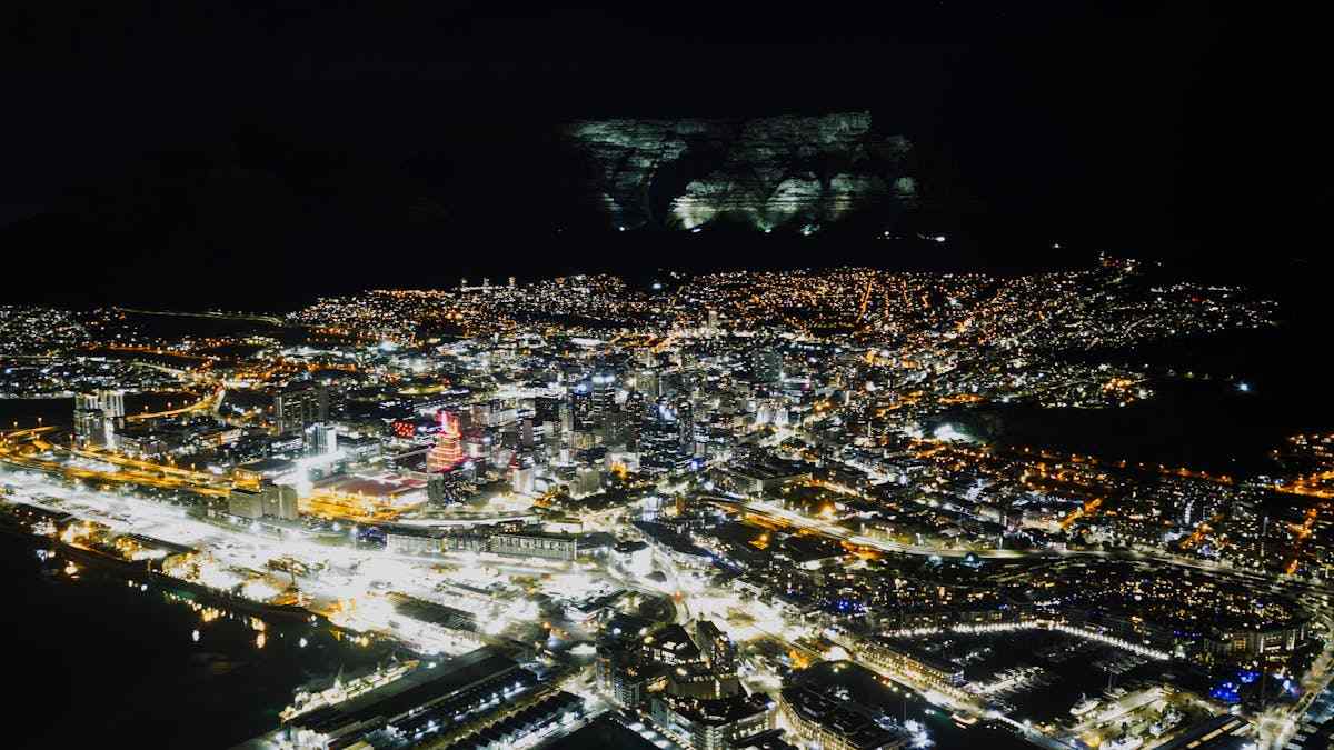 Aerial night view of Cape Town cityscape with Table Mountain illuminated, South Africa
