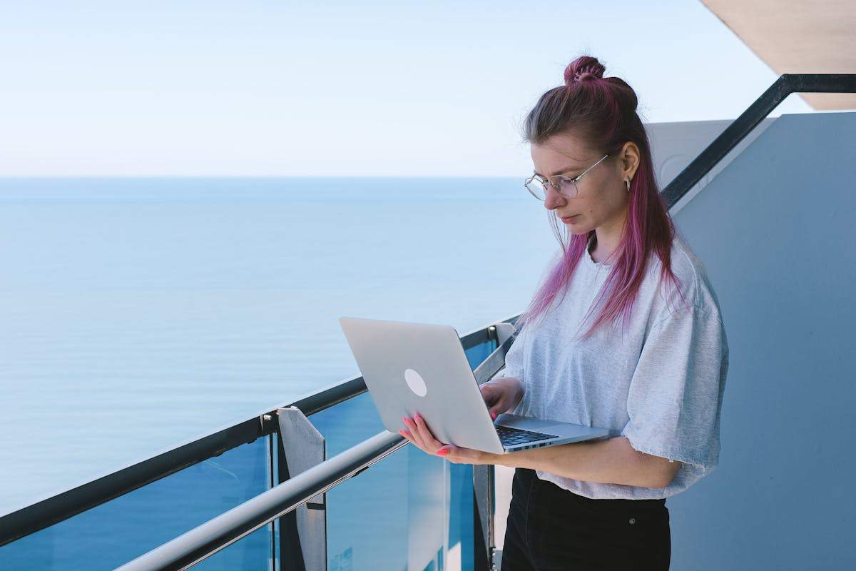 Digital Nomad Visas for Americans: The Complete Country-by-Country Guide (2026) 4 Woman working remotely by the sea on laptop - digital nomad visa options for Americans