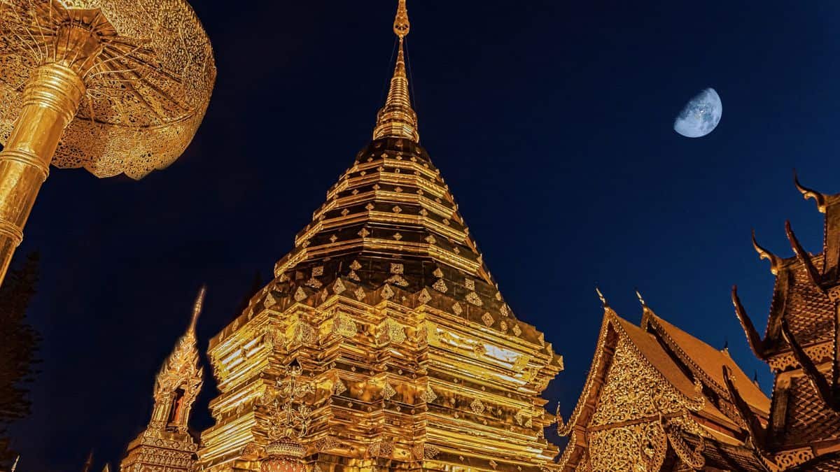 Moving to Thailand as an American: 7 Things Nobody Tells You (2026) 2 Golden chedi of Wat Phra That Doi Suthep lit at night in Chiang Mai, Thailand