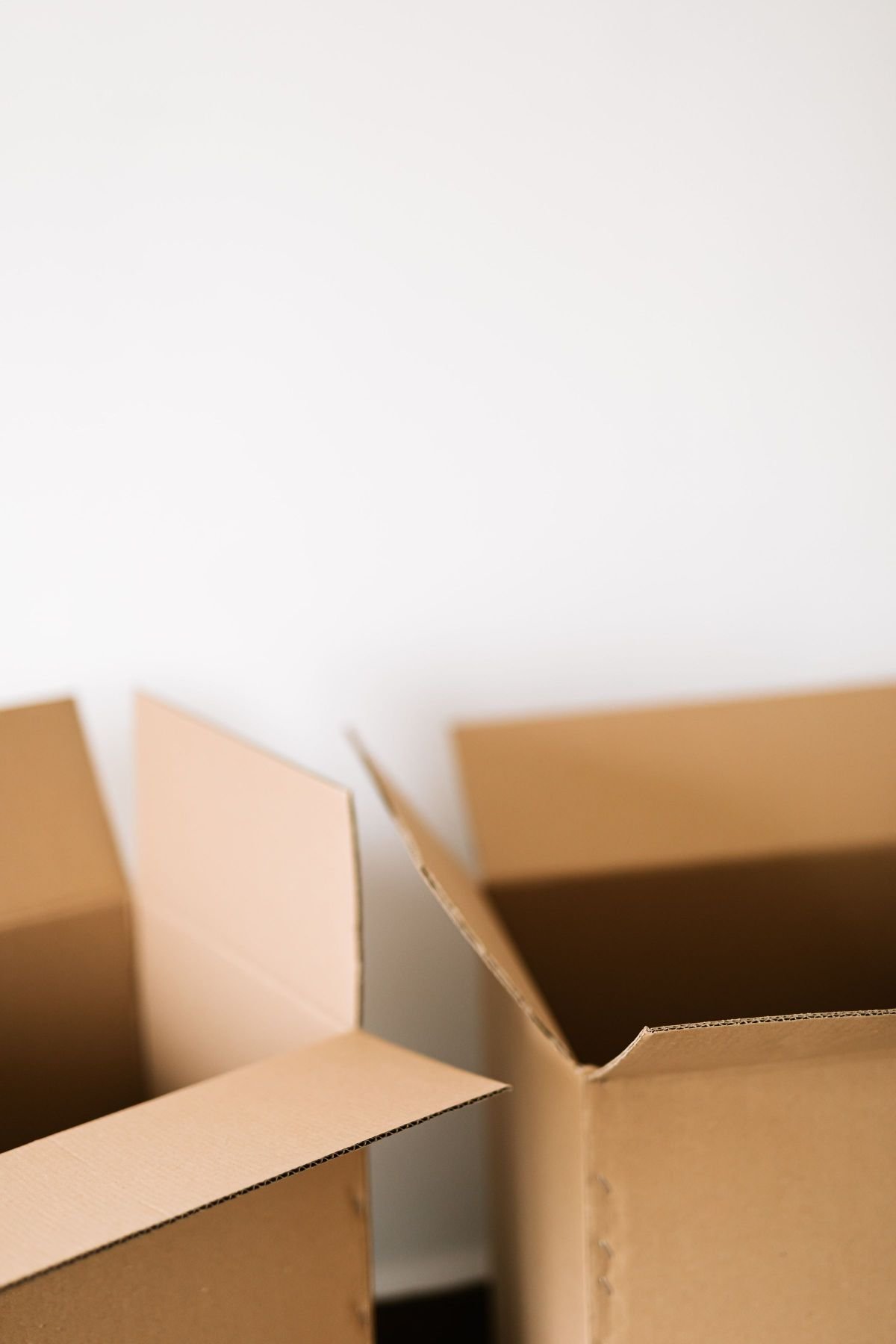 Sell Everything and Move Abroad: The 7 Real Numbers From My Move 1 Open empty cardboard boxes on the floor against a plain white wall
