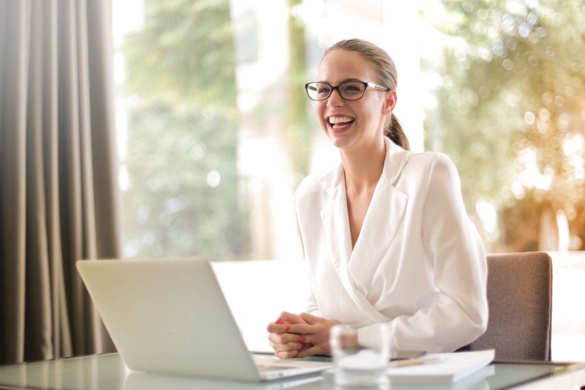 Moving to Spain from the US: 2026 Complete Guide for Americans 4 Woman smiling while working on a laptop at a bright desk